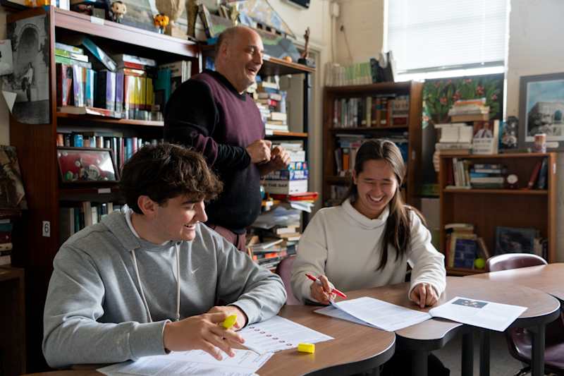Sebastian L. and Kate C. work on the Belfield Banter with club advisor Jordan Taylor